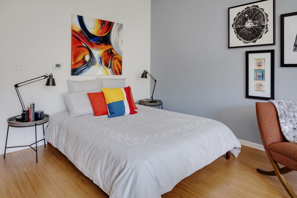 a bedroom with a white bed and colorful pillows